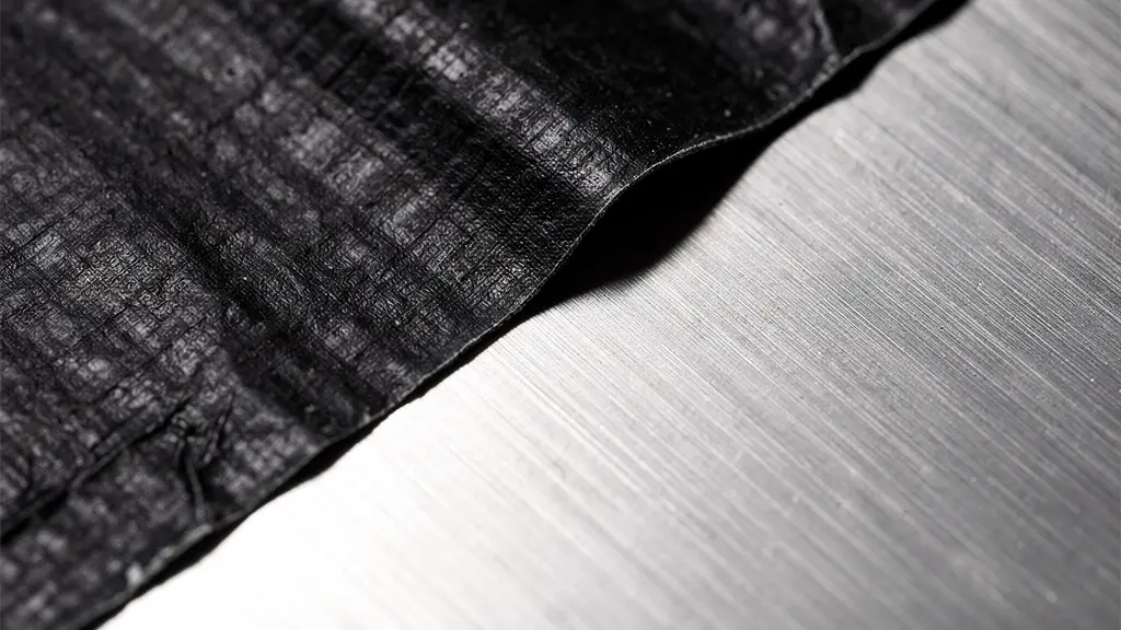 Vue macro d'un ruban adhésif noir appliqué sur une surface métallique polie pour mesure thermographique